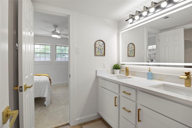 ensuite bathroom featuring a sink, baseboards, ensuite bathroom, and double vanity