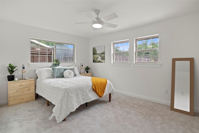 carpeted bedroom with baseboards, multiple windows, and ceiling fan