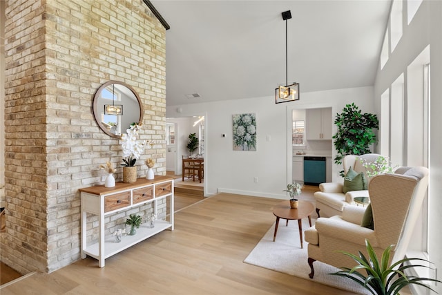 living room featuring light wood-style floors, baseboards, and high vaulted ceiling