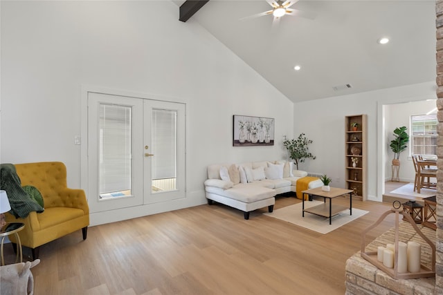living room featuring high vaulted ceiling, visible vents, french doors, and light wood-style flooring
