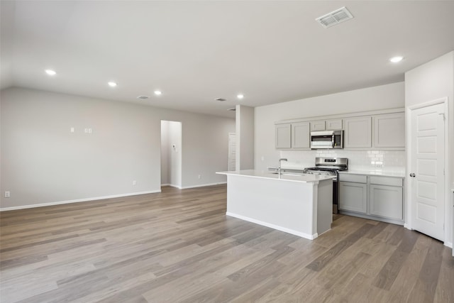 kitchen featuring recessed lighting, backsplash, gray cabinetry, and stainless steel appliances
