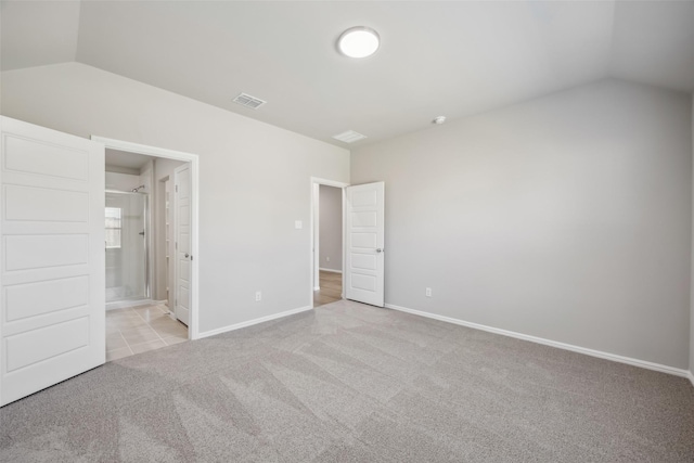 unfurnished bedroom featuring connected bathroom, light carpet, baseboards, vaulted ceiling, and visible vents