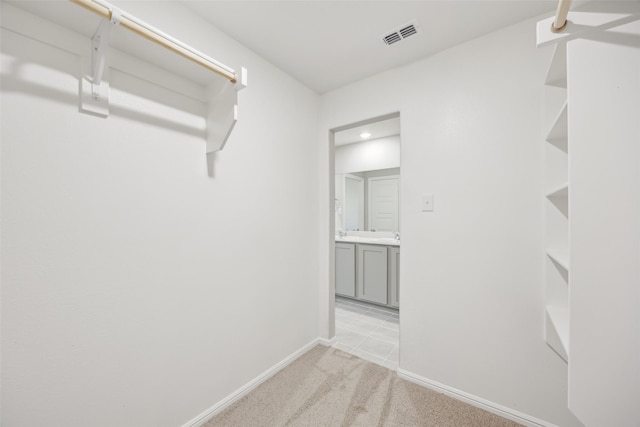 walk in closet with visible vents and light carpet