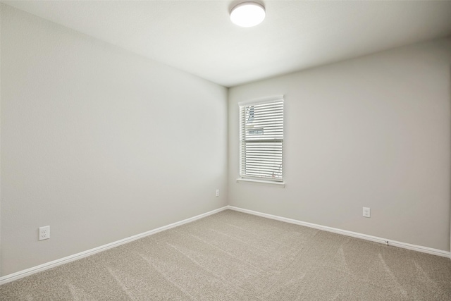 carpeted spare room featuring baseboards