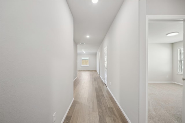 corridor with recessed lighting, baseboards, and wood finished floors