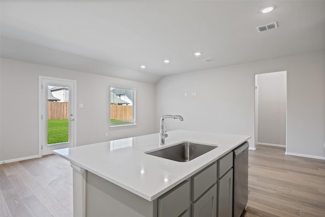 kitchen with gray cabinets, visible vents, light wood-type flooring, a sink, and light countertops