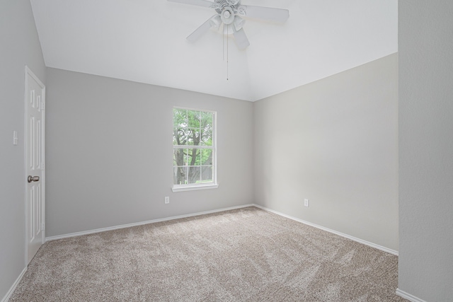 carpeted spare room featuring baseboards, ceiling fan, and vaulted ceiling