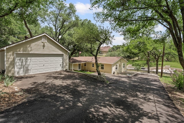 2311 Cedar Cir, Granbury, TX 76048 - view of front facade featuring a garage and view of wooded area