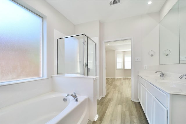 2625 Cumberland Trl, Balch Springs, TX 75181 - bathroom featuring a garden tub, visible vents, a stall shower, wood finished floors, and a sink