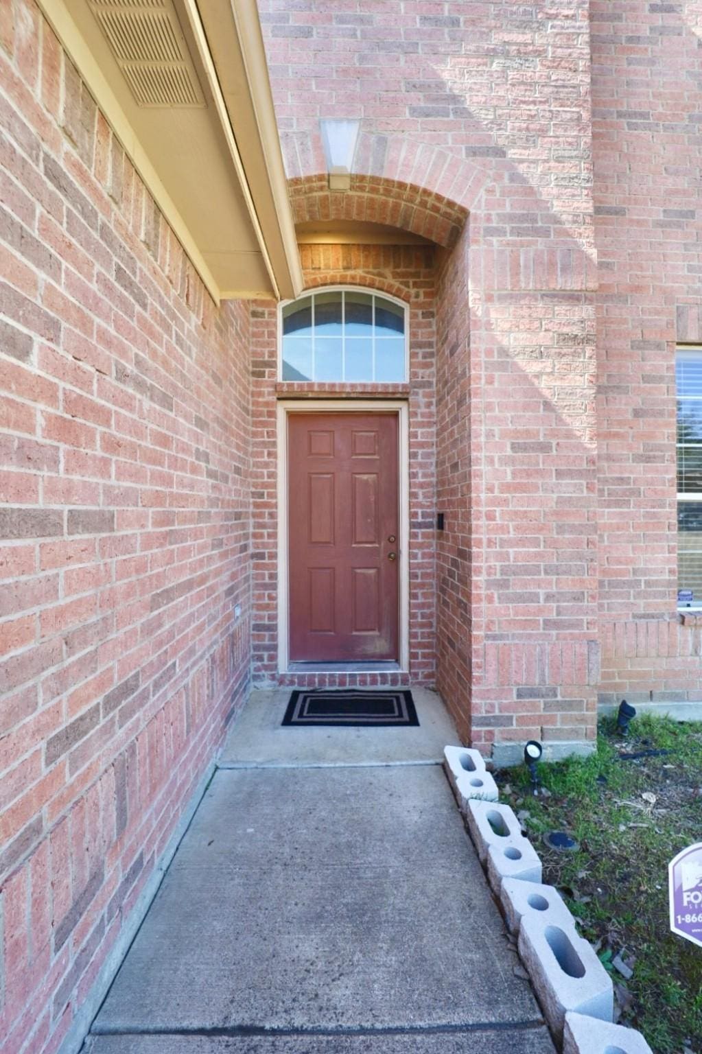 property entrance with brick siding and visible vents