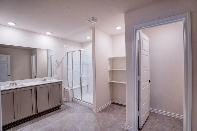 full bath featuring double vanity, baseboards, a shower stall, and a sink