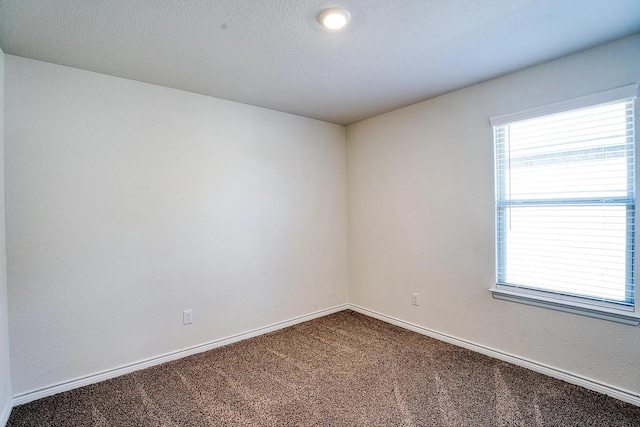 carpeted spare room featuring baseboards