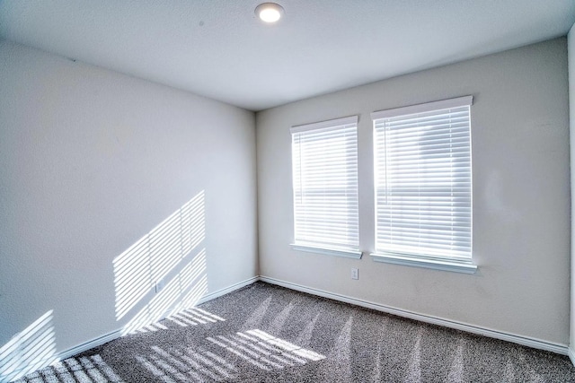 carpeted empty room with baseboards