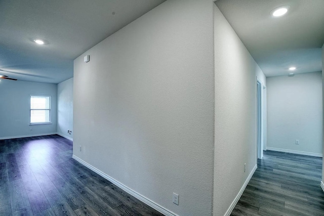 hall featuring dark wood-style flooring, baseboards, and recessed lighting