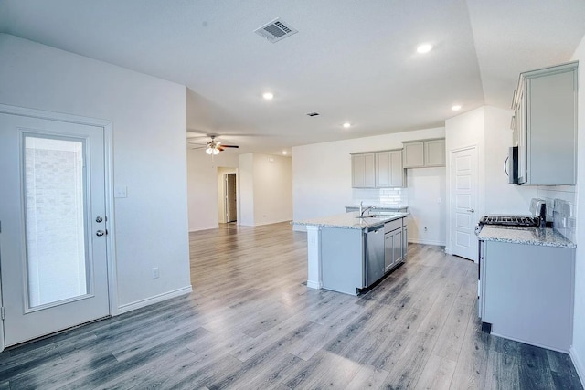 kitchen with ceiling fan, appliances with stainless steel finishes, a sink, light wood-style flooring, and gray cabinetry