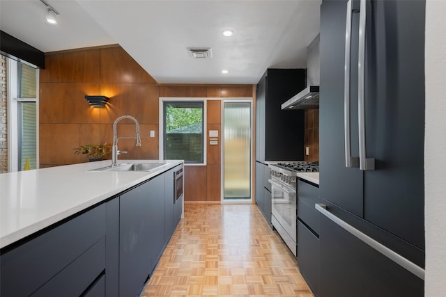 kitchen with light countertops, appliances with stainless steel finishes, a sink, and modern cabinets