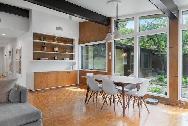 dining area with a high ceiling, beamed ceiling, and visible vents