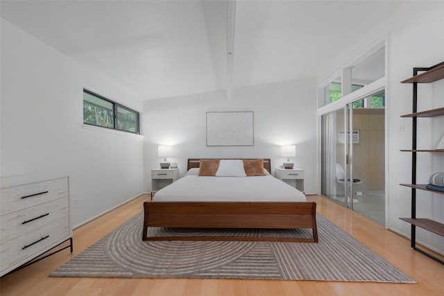 bedroom featuring beamed ceiling and light wood-style flooring