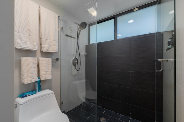 full bath with tile patterned floors, a tile shower, and toilet