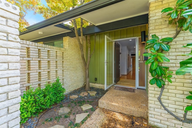 property entrance with brick siding and board and batten siding
