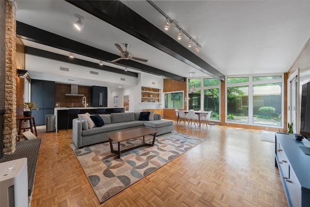 living room with beamed ceiling, a ceiling fan, and visible vents