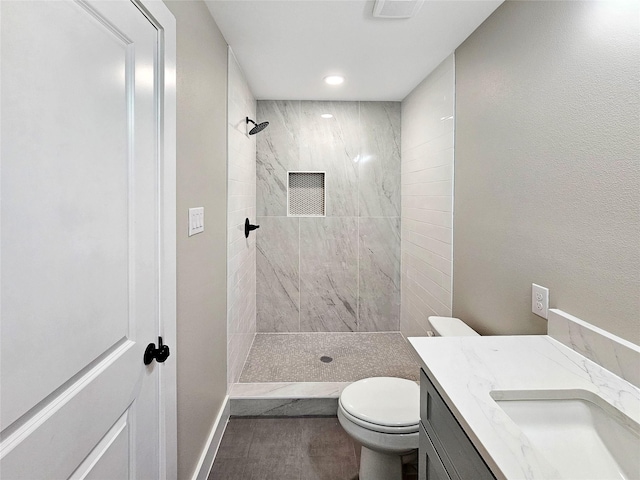 8622 Eden Valley Ln, Dallas, TX 75217 - full bathroom with a tile shower, vanity, toilet, and recessed lighting