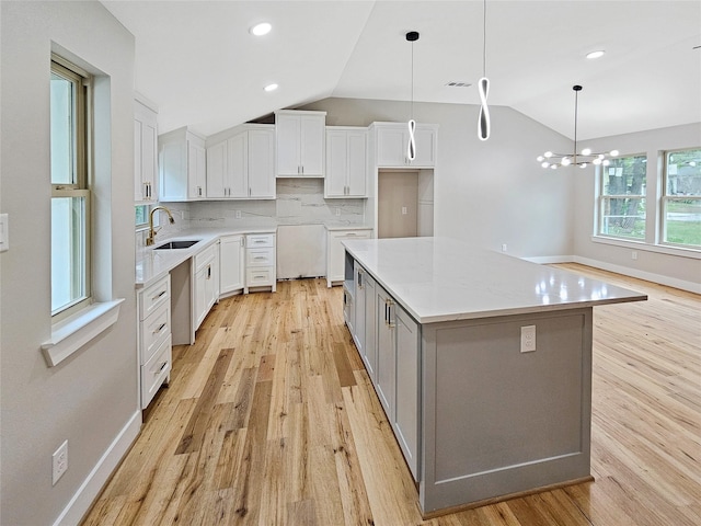 8622 Eden Valley Ln, Dallas, TX 75217 - kitchen with a sink, lofted ceiling, light wood-style flooring, white cabinetry, and recessed lighting