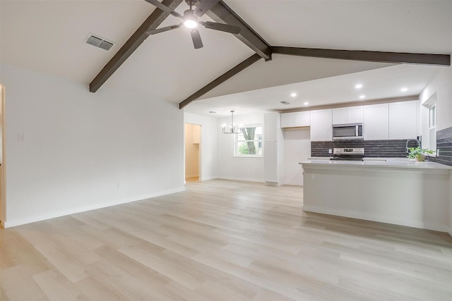 kitchen with visible vents, a peninsula, white cabinets, ceiling fan with notable chandelier, and stainless steel appliances