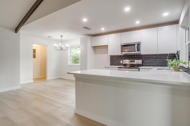 kitchen with visible vents, decorative backsplash, light countertops, a sink, and stainless steel appliances