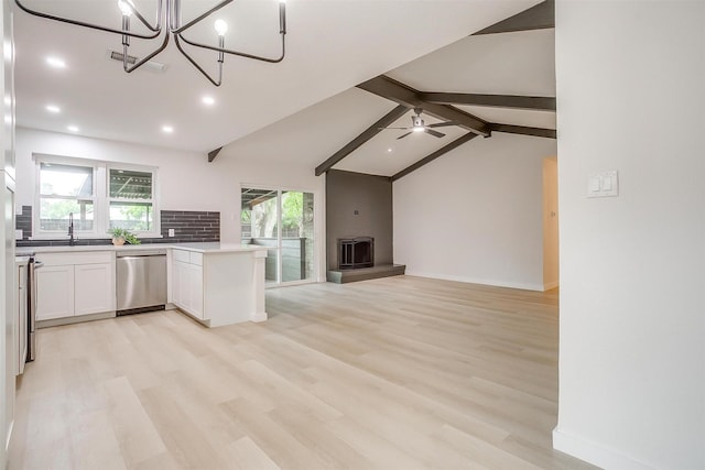kitchen featuring stainless steel dishwasher, open floor plan, light wood-style flooring, and white cabinets