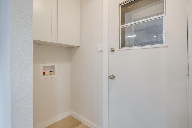 laundry area featuring baseboards, hookup for a washing machine, and cabinet space