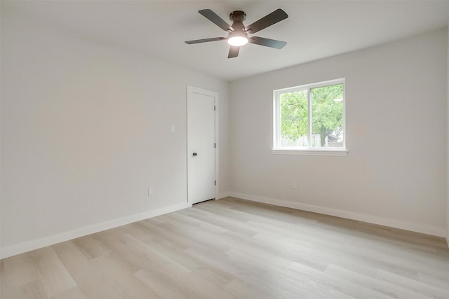 unfurnished room with light wood-type flooring, a ceiling fan, and baseboards