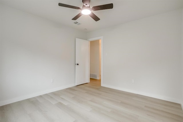 unfurnished room featuring a ceiling fan, baseboards, visible vents, and light wood-type flooring