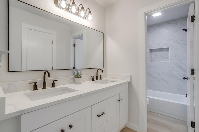 full bathroom with double vanity, shower / bath combination, and a sink