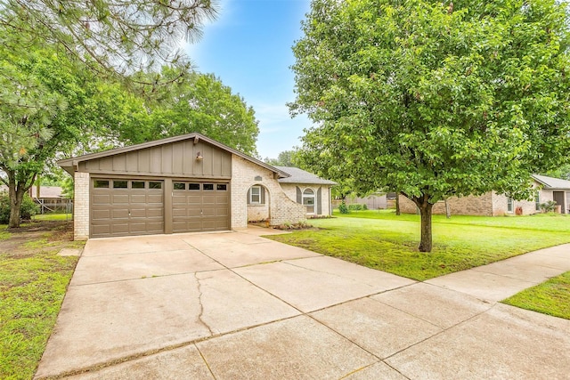 view of front of home featuring brick siding, a garage, board and batten siding, a front yard, and concrete driveway