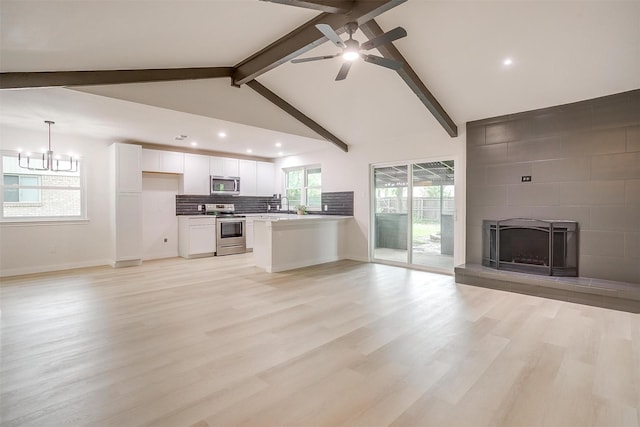 unfurnished living room featuring a fireplace, ceiling fan with notable chandelier, recessed lighting, vaulted ceiling with beams, and light wood-type flooring