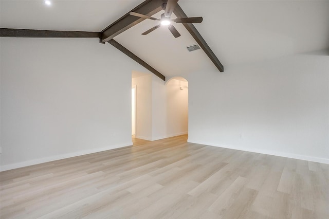 unfurnished room featuring light wood-style floors, arched walkways, a ceiling fan, vaulted ceiling with beams, and visible vents