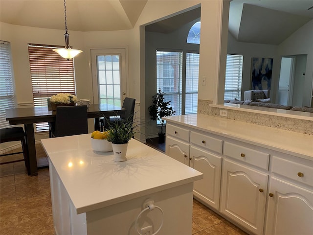 kitchen with light countertops, white cabinetry, light tile patterned floors, and lofted ceiling