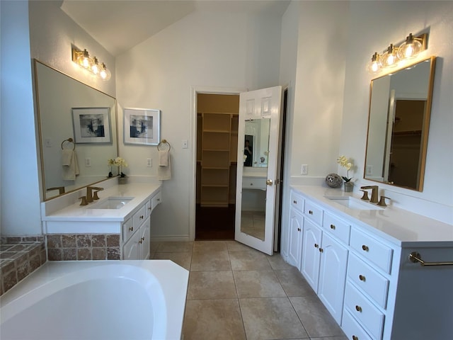 full bath with a sink, tile patterned flooring, two vanities, and a spacious closet