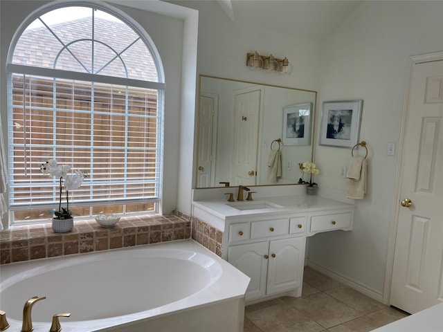 bathroom with tile patterned floors, a bath, and vanity