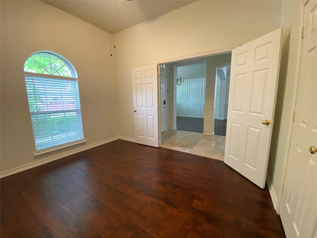 spare room featuring baseboards and wood finished floors