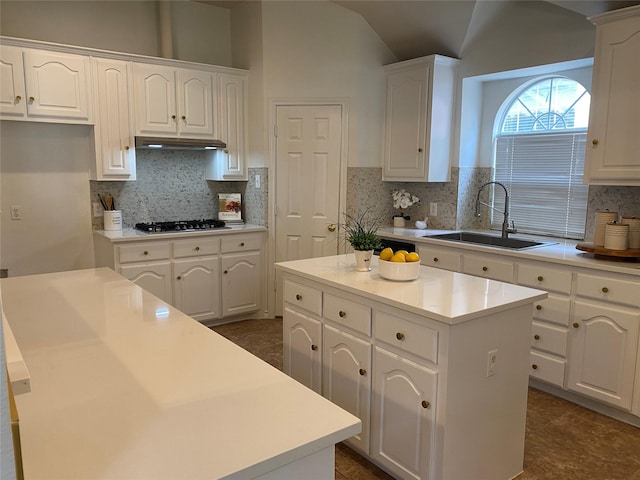 kitchen with a sink, a center island, stainless steel gas cooktop, and white cabinetry