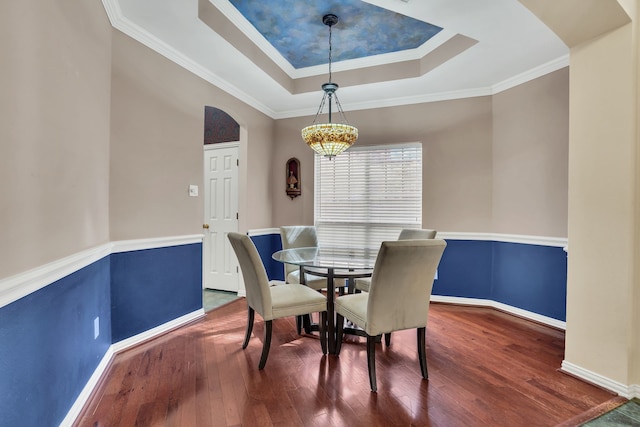 2630 Lakeforest Ct, Dallas, TX 75214 - dining room with arched walkways, a tray ceiling, baseboards, wood finished floors, and ornamental molding
