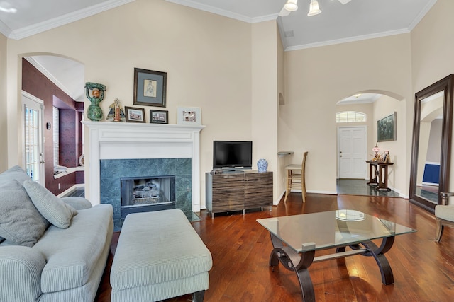 2630 Lakeforest Ct, Dallas, TX 75214 - living area with arched walkways, wood finished floors, a premium fireplace, baseboards, and crown molding