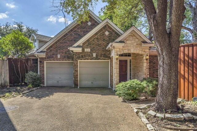 2630 Lakeforest Ct, Dallas, TX 75214 - view of front facade with driveway, an attached garage, brick siding, and stone siding