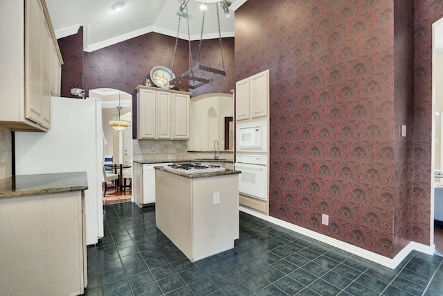 2630 Lakeforest Ct, Dallas, TX 75214 - kitchen with white appliances, ornamental molding, wallpapered walls, a kitchen island, and dark tile patterned flooring