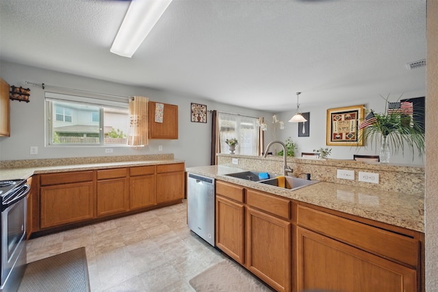 kitchen featuring light countertops, brown cabinets, appliances with stainless steel finishes, and a sink