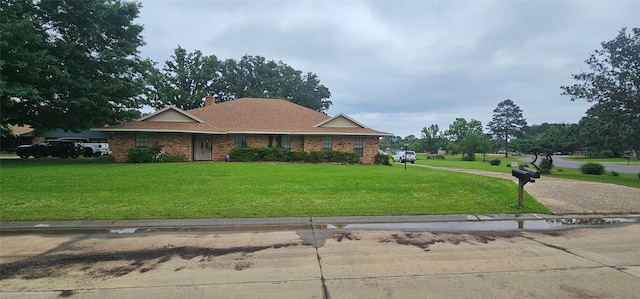 2 Woodfern Ln, Haughton, LA 71037 - view of front of home featuring roof with shingles, a chimney, brick siding, and a front yard