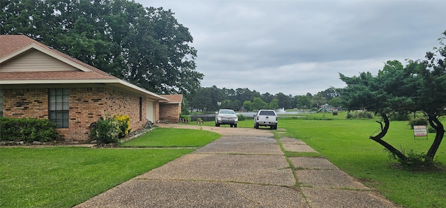 2 Woodfern Ln, Haughton, LA 71037 - view of home's exterior with brick siding, roof with shingles, a yard, and concrete driveway