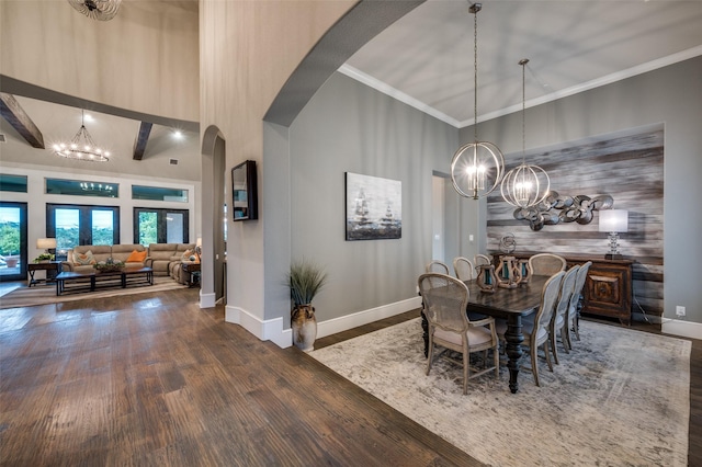 dining space featuring arched walkways, a notable chandelier, and wood finished floors